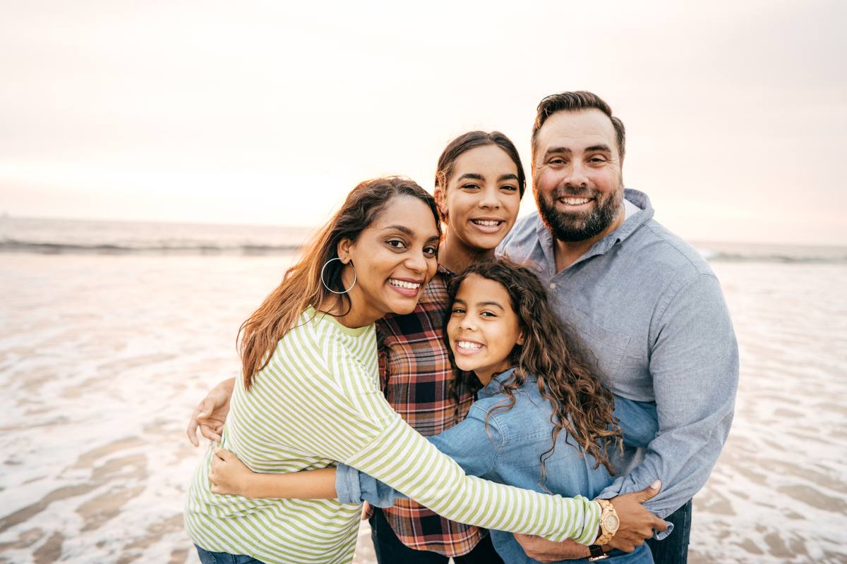 A host family standing together outdoors at sunset
